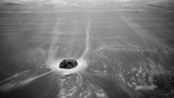 Long exposure of a stone in the sand