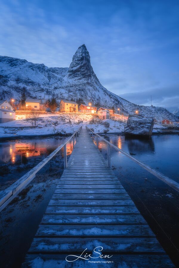 This is a famous place for photography in Reine village. However, there is a few people here when you come at golden and blue hour.Try to use the bridge as foreground, and maybe during the winter you can shoot with aurora.