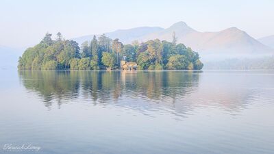 View of Derwent Island on Derwent Water in the early morning mist from Crow Park.