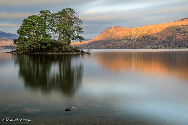Looking across Derwent Water from Abbot’s Bay with light on Falcon Crag behind Otter Island.