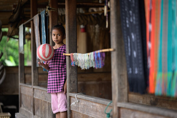Bena traditional village - local girl with a ball