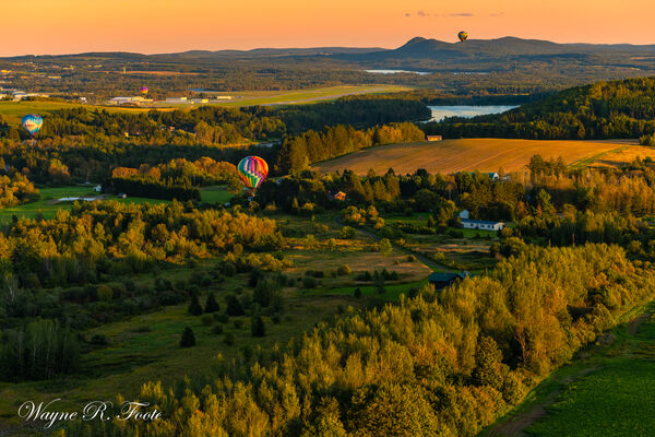Four balloons flying over Maine countryside during Golden Hour. Shot from 