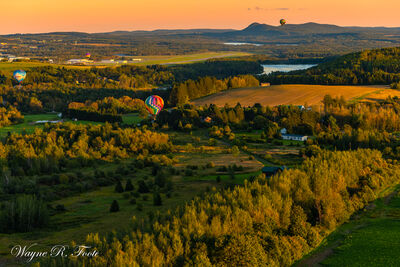 Four balloons flying over Maine countryside during Golden Hour. Shot from 