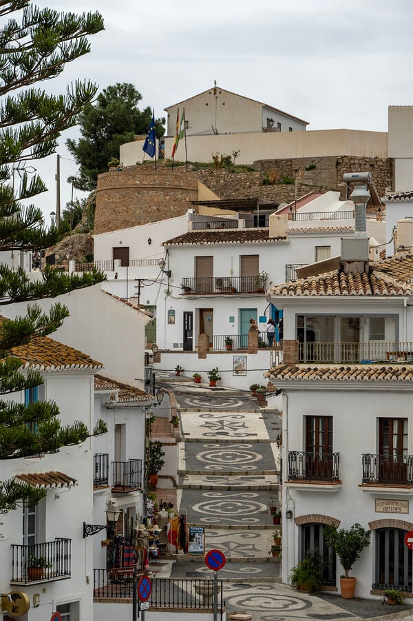 From the town center, this small path takes you up towards Tourist Information, the Mayers office and a a view over a football stadium and a view down the valley. 
The steps on the path is set with stones in white and black patterns that is so typical og Frigiliana 