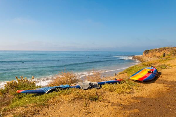 Surfboards wait on the cliff at Ventura County Line, California, USA.