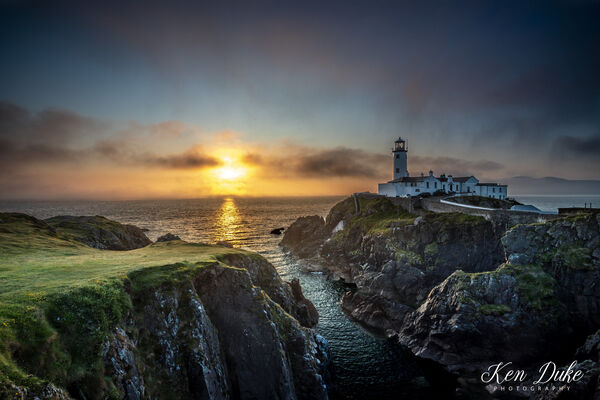 prior to this shot it was foggy, I could only see the light from the lighthouse, then boom, fog started to lift just as the sun started to rise.
